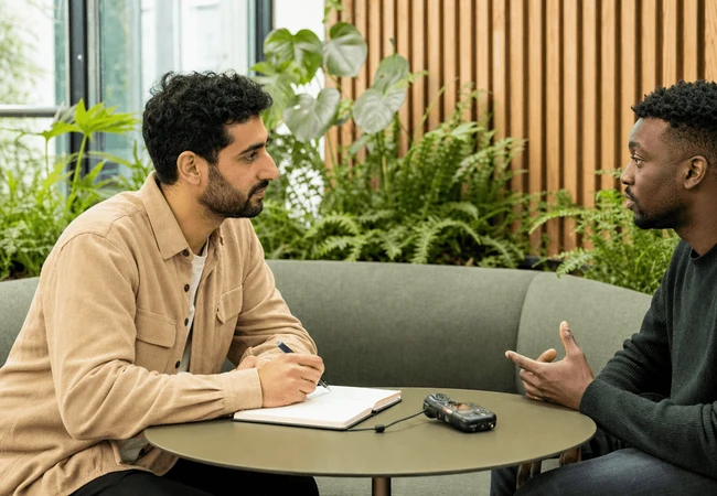 A male UX researcher interviewing a colleague